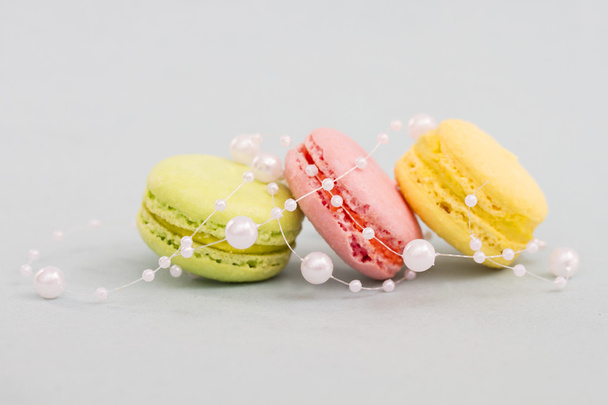 French multicolored macaroon cookies entwined with pearl beads - Photo, Image