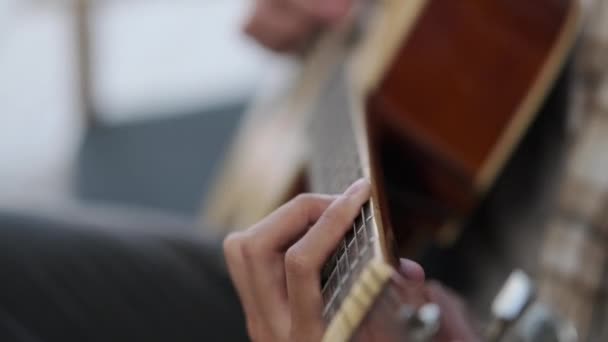 Κοντινό πλάνο του χεριού παίζει ακουστική κιθάρα στον καναπέ. Μουσική, ψυχαγωγία και ψυχαγωγικές δραστηριότητες. - Πλάνα, βίντεο