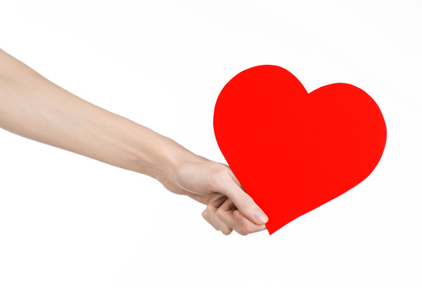 Valentine's Day and love theme: hand holding a red heart isolated on a white background in studio - Photo, Image