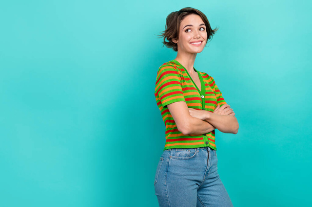 Photo of confident dreamy lady wear striped cardigan arms crossed looking back empty space isolated teal color background. - Foto, Imagem