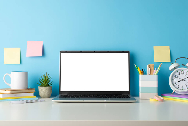 Transform your distant education materials with a side view capture of a white desk, computer and school supplies on an isolated blue background, designed for text or advertising incorporation - Photo, Image