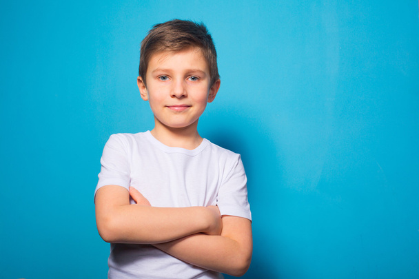 Photo of adorable young happy boy looking at camera on blue back - Foto, Imagen