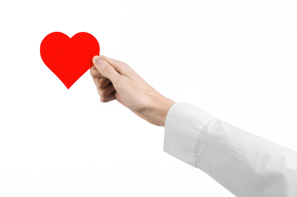 Thème : médecin de la main en chemise blanche tenant une carte sous la forme d'un cœur rouge isolé sur un fond blanc en studio
 - Photo, image