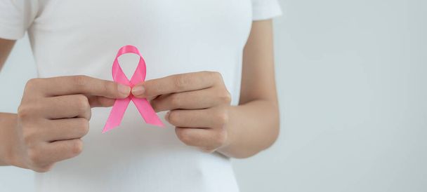 女性はピンクのリボン乳癌の意識を保持する。女性の健康診断意識。国際女性デーと世界がんデー。がんにサインする,象徴的,健康管理,患者を支援する,タイムリーな診断 - 写真・画像