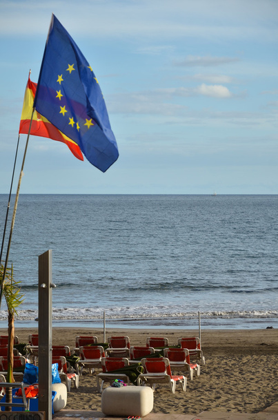 Flagi na plaży z leżakami - Zdjęcie, obraz