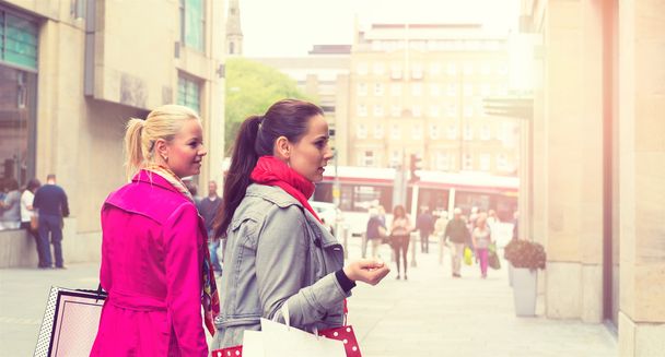 Two attractive young female friends enjoying a day out shopping - 写真・画像
