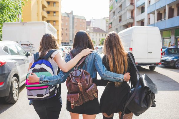Volver ver tres jóvenes mujeres felices amigos caminando al aire libre abrazos divertirse - Foto, imagen