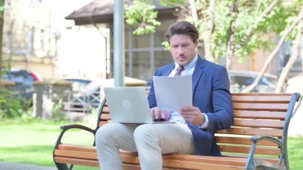 Moyen Age Homme d'affaires travaillant sur des documents et ordinateur portable en plein air - Séquence, vidéo
