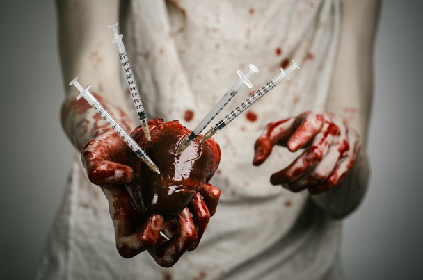 Publicidade social e luta contra a toxicodependência: mãos ensanguentadas, com seringa e coração humano ensanguentado
 - Foto, Imagem