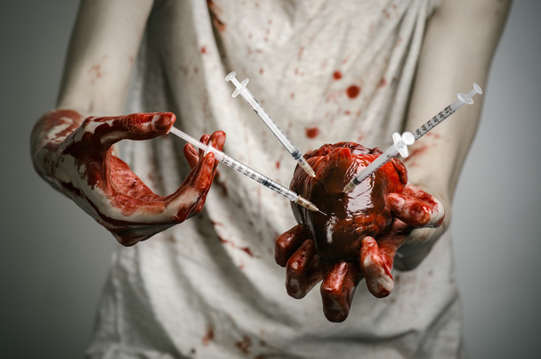 Social advertising and the fight against drug addiction: bloody hands addict holding syringe and bloody human heart - Foto, Imagen