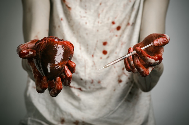 Social advertising and the fight against drug addiction: bloody hands addict holding syringe and bloody human heart - 写真・画像