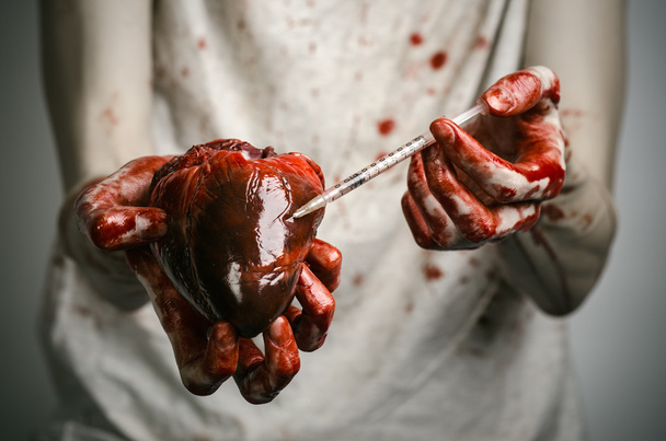 Social advertising and the fight against drug addiction: bloody hands addict holding syringe and bloody human heart - Foto, Imagem