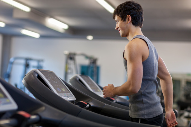 Trained man is running on a treadmill - Zdjęcie, obraz