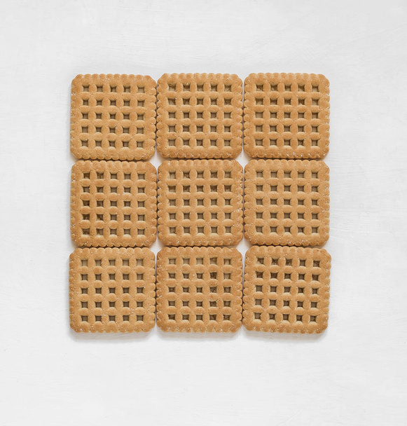 Dolci biscotti di forma quadrata su fondo bianco. Vista dall'alto. - Foto, immagini