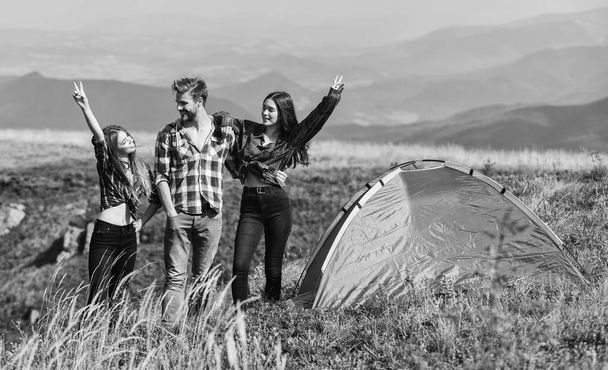 Feel freedom. Happiness concept. Hiking activity. Friends set up tent on top mountain. Camping gear. Camping equipment. Weekend in mountains. Man and girls having fun in nature. Camping tent. - Fotoğraf, Görsel