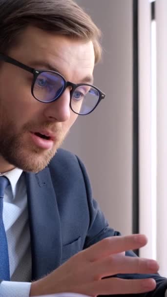 Pain in the heart of an office worker working on a laptop while sitting at a desk in the office. Myocardial infarction. Overworked at work. Vertical video - Imágenes, Vídeo