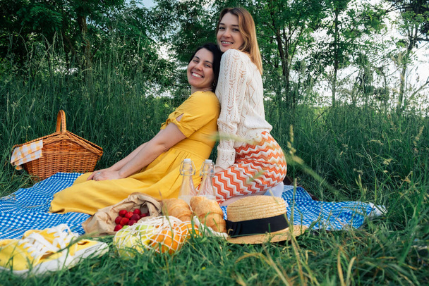 Two friends on blue blanket for an outdoor picnic - Fotografie, Obrázek