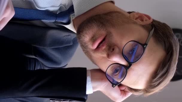 The manager falls asleep at the workplace in the office, he is tired from hard work at the computer. Vertical video - Séquence, vidéo