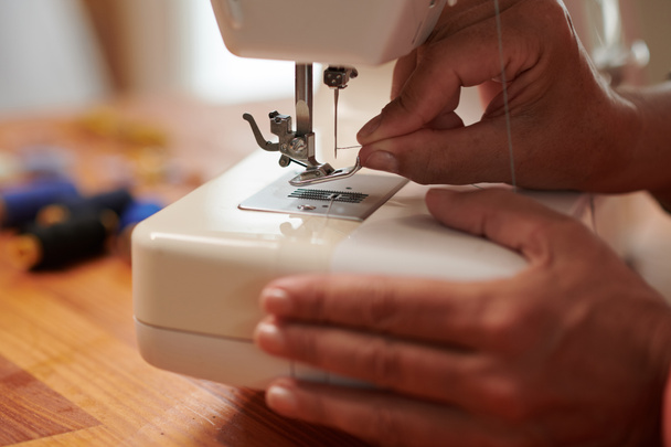Imagen de cerca de costurera roscando aguja de la máquina de coser - Foto, imagen