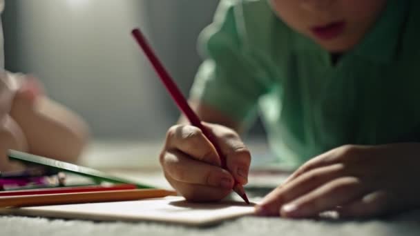 Un primo piano di mani di un ragazzo che disegna con matite su un pezzo di carta. Il tempo divertente è passato a casa, il bambino è impegnato e impara l'arte. Filmati 4k di alta qualità - Filmati, video