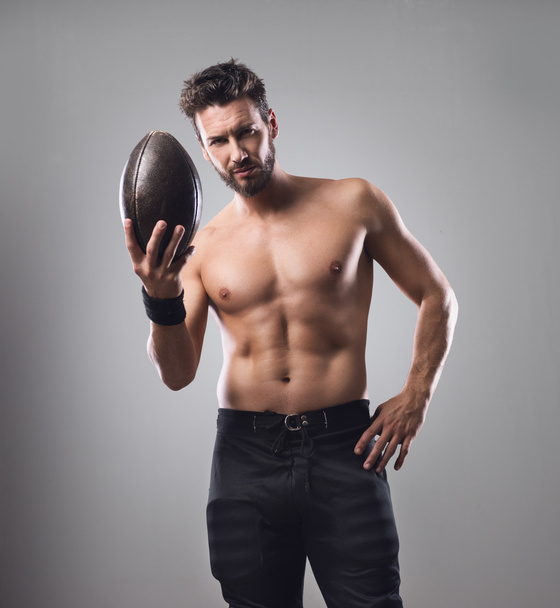 Football player holding ball - Foto, Imagen