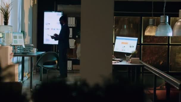 Πυροβολισμός Αφροαμερικανών υπαλλήλων που έλεγχαν αναφορές μισθοδοσίας και πίνακες σε οθόνη υπολογιστή κατά τη διάρκεια της νυχτερινής βάρδιας. Προσωπικό της εταιρείας που εργάζεται τη νύχτα για το έργο πριν από τη λήξη της προθεσμίας - Πλάνα, βίντεο