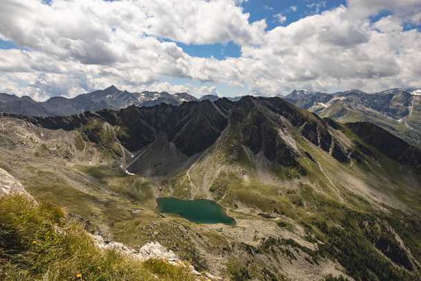 Uma bela paisagem de montanha com picos, um lago de montanha de cor azul e um céu com belas nuvens. Foto de alta qualidade - Foto, Imagem