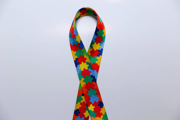σύμβολο του αυτισμού - χρωματιστή κορδέλα με σχέδια χρωματιστά κομμάτια παζλ - Φωτογραφία, εικόνα