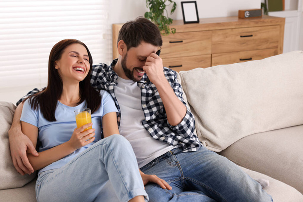 Couple watching comedy via TV and laughing at home - Foto, immagini