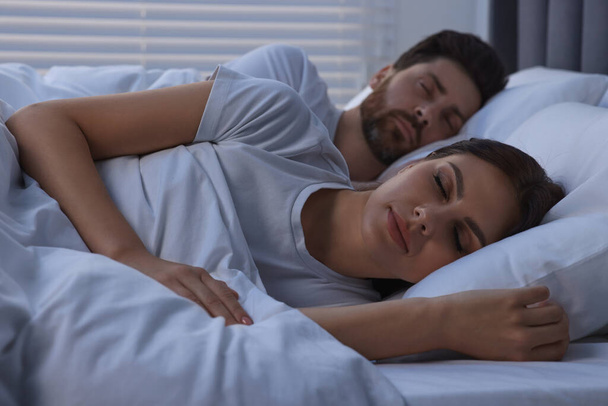 Lovely couple sleeping together in bed at night - Photo, Image
