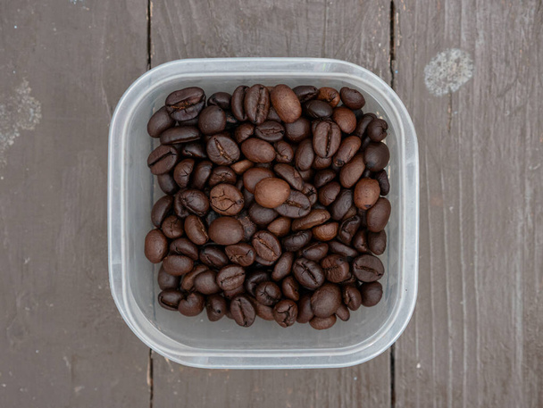 вид кофейных зерен в прозрачном пластиковом контейнере - Фото, изображение