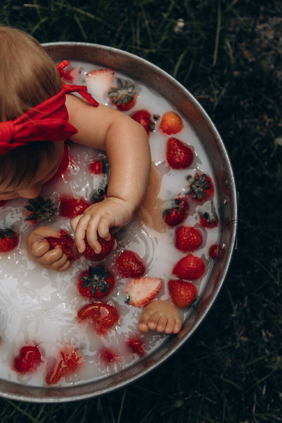 Девушка купается в ванне с молоком и клубникой - Фото, изображение