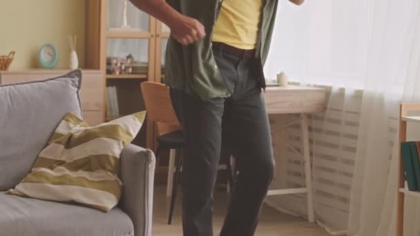 Kallistaa aktiivinen valkoihoinen vanhempi mies pitkä harmaa parta tanssia energisesti kotona kuunnellen musiikkia langattomissa kuulokkeissa - Materiaali, video