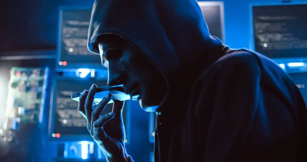 Egy maszkot viselő hacker számítógéppel töri fel az adatokat, hogy váltságdíjat kapjon az áldozatoktól.. - Fotó, kép