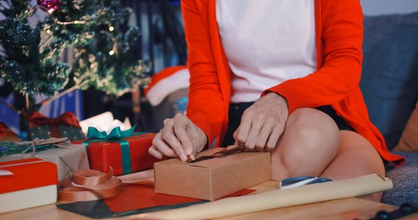 vrouw bereidt cadeautjes voor vrienden op kerstfeest thuis. - Foto, afbeelding