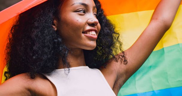 若い黒人女性が,誇りあるパレードで,同性愛の象徴である虹の旗を振る. - 写真・画像