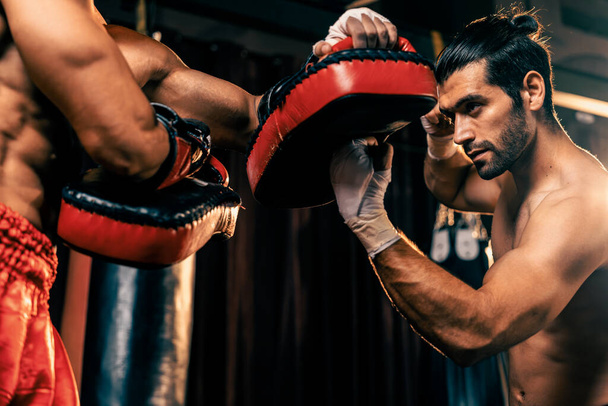 Aasian ja Kaukasian Muay Thai nyrkkeilijä vapauttaa ylempi leikkaus booli hyökkäys kovaa nyrkkeily koulutus istunto, toimittaa lyönti lakko sparraus kouluttaja, esittelee Muay Thai nyrkkeily tekniikka ja taito. Virikkeitä - Valokuva, kuva