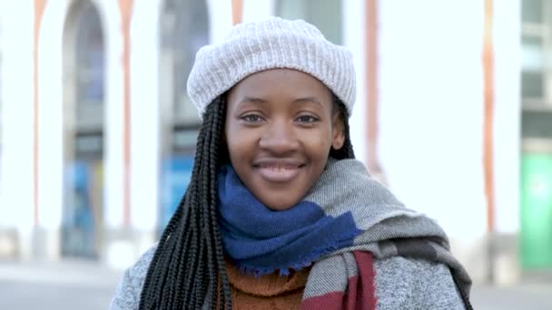 カメラを見て冬に微笑んでいるアフリカの若い女性の肖像画. - 映像、動画