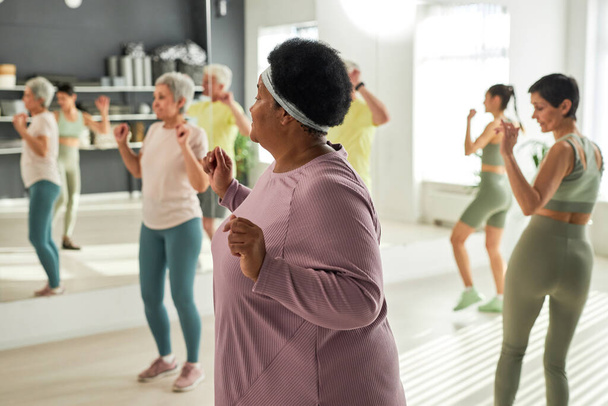 Group of elderly people exercising together in gym together with coach - Photo, Image
