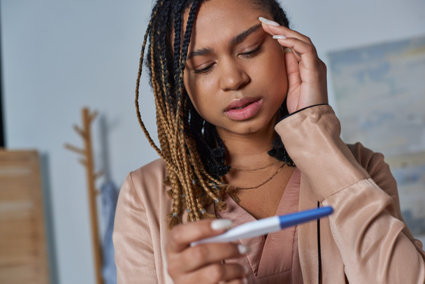abortusconcept, Afrikaans-Amerikaanse vrouw kijkt naar zwangerschapstest en neemt beslissingen, onzekerheid - Foto, afbeelding