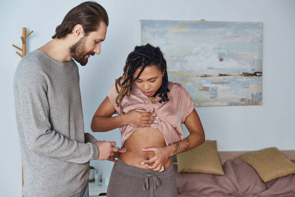 アフリカ系アメリカ人の妻,タトゥー,不妊,カップルの腹部にホルモン注射をするひげ付き男性 - 写真・画像