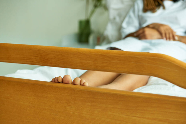 vista recortada de mujer afroamericana descalza, dedos de los pies, sensación desnuda, hospital sala privada, acostado - Foto, imagen