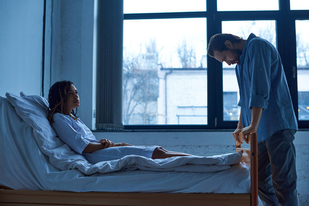 man grieving near depressed african american wife, standing near hospital ward, miscarriage concept - Фото, зображення