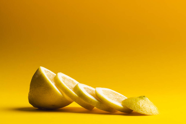Close up of sliced lemon with copy space on yellow background. Fruit, food, freshness and colour concept. - Photo, Image