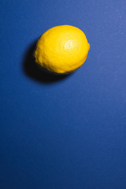 Close up of lemon and copy space on blue background. Fruit, exotic fruit, food, freshness and colour concept. - Photo, Image