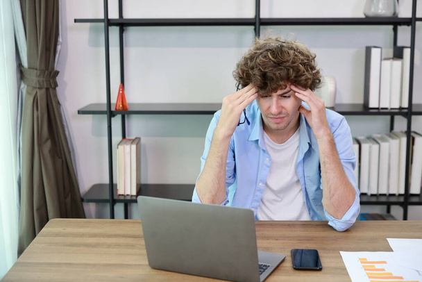 Jovem empresária adulta tocando sua cabeça na mesa no escritório após o fracasso do negócio de más notícias ou ser demitido e sentir-se desencorajado, perturbado e sem esperança no escritório moderno.  - Foto, Imagem