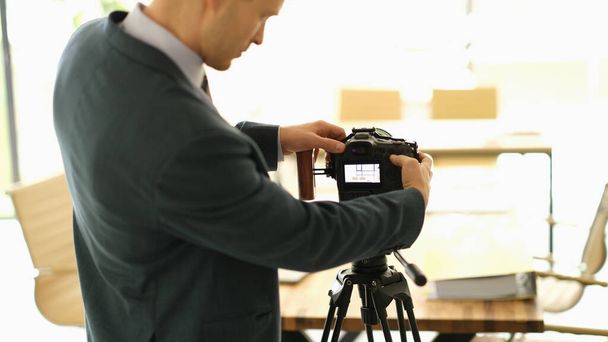 Photographer in studio adjusts settings of camera. Freelancer amateur photographer - Photo, Image