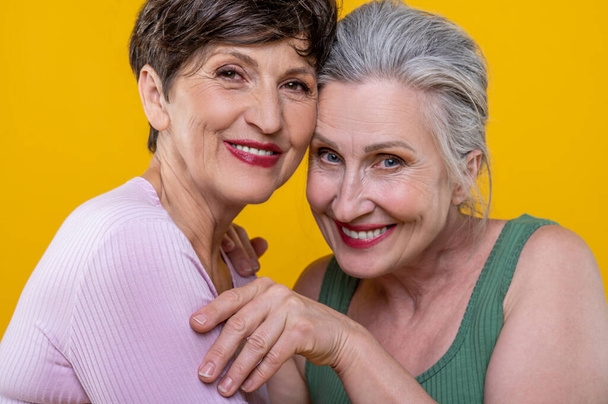 Women. Active senior women standing close and smiling happily - Photo, image