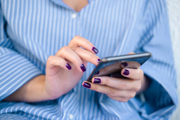 Женщина с помощью мобильного телефона набирает текст, проверяет социальные сети или покупки в Интернете. - Да. Высокое качество фото - Фото, изображение