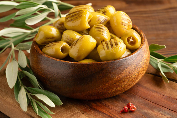 Olive verdi grigliate su fondo di legno - Foto, immagini